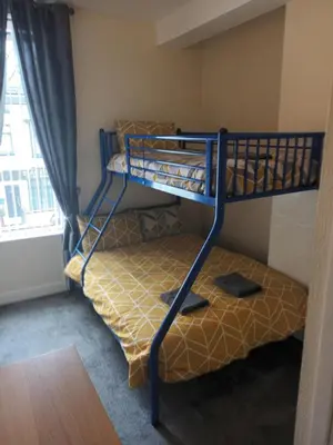two bunk beds in a small room with a window at Strides Hotel in Blackpool