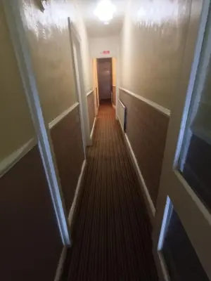 a hallway leading to a room with a door and a hallwayngth at Strides Hotel in Blackpool