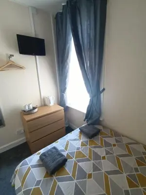 a bedroom with a bed with two towels on it at Strides Hotel in Blackpool