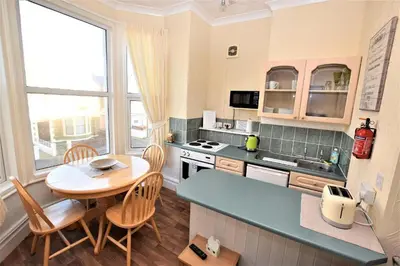 a kitchen with a table and a table and chairs at Bridle Lodge Apartments in Blackpool