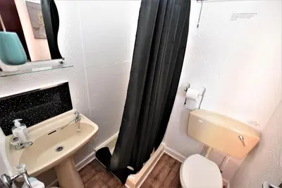a small bathroom with a toilet and a sink at Bridle Lodge Apartments in Blackpool