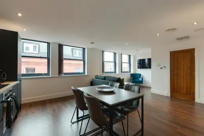 a living room with a table and a couch at Mathew Street City Centre Apartments by Happy Days in Liverpool