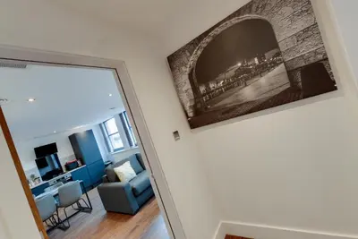 a living room with a wall with a picture on the wall at Mathew Street City Centre Apartments by Happy Days in Liverpool