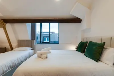 two beds in a room with a window at Mathew Street City Centre Apartments by Happy Days in Liverpool