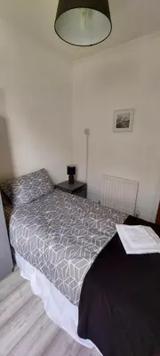 a bedroom with a bed and a table with a lamp at the belvere in Blackpool