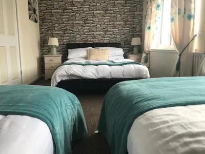 a bedroom with two beds and a brick wall at the belvere in Blackpool