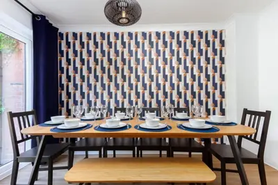 a dining room table with chairs and wine glasses at Avella by the Park in Lytham St Annes