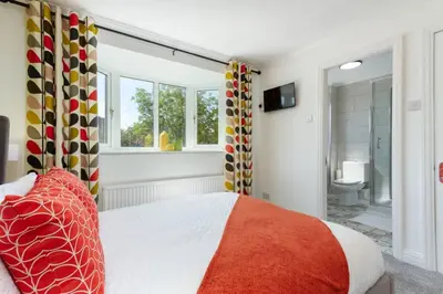 a bedroom with a bed and a bathroom at Avella by the Park in Lytham St Annes
