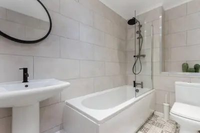 a bathroom with a sink and a tub and a toilet at Avella by the Park in Lytham St Annes