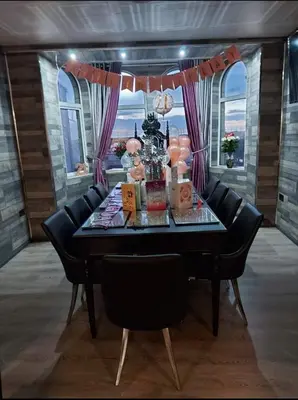 a dining room table with black chairs and purple curtains at Kings Boutique Hotel in Blackpool