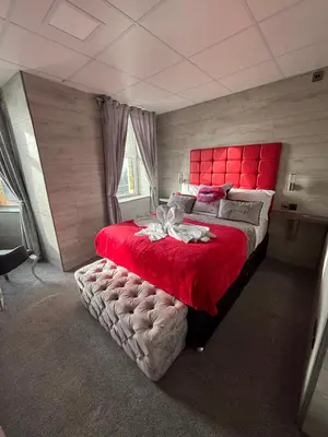 a bedroom with a large bed with a red headboard at Kings Boutique Hotel in Blackpool