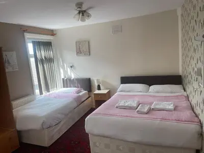 a bedroom with two beds and a window at White Moon Hotel in Blackpool