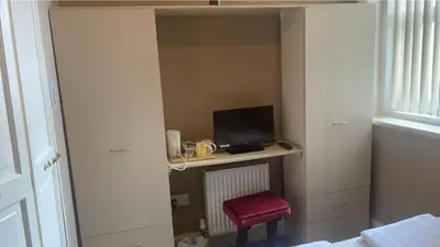 a room with a desk with a monitor and a chair at White Moon Hotel in Blackpool