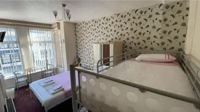 a bedroom with a bed and a wall with birds on it at White Moon Hotel in Blackpool
