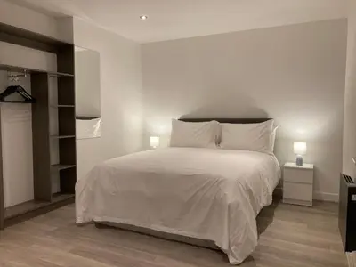 a bedroom with a large white bed with two lamps at Coastal Plaza in Blackpool