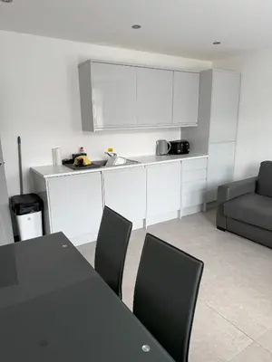 a kitchen with a table and chairs and a couch at Coastal Plaza in Blackpool