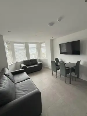a living room with a couch and a table with chairs at Coastal Plaza in Blackpool