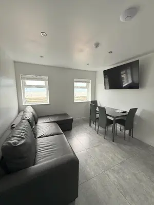 a living room with a couch and a table with chairs at Coastal Plaza in Blackpool
