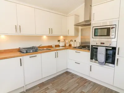 a white kitchen with white cabinets and appliances at Eden Lodge - Sherwood 21 in Carnforth