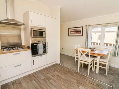 a kitchen and dining room with a table and chairs at Eden Lodge - Sherwood 21 in Carnforth