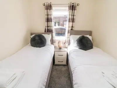 two twin beds in a room with a window at Eden Lodge - Sherwood 21 in Carnforth