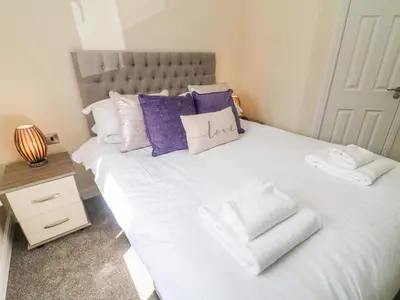 a large white bed with pillows and towels on it at Eden Lodge - Sherwood 21 in Carnforth