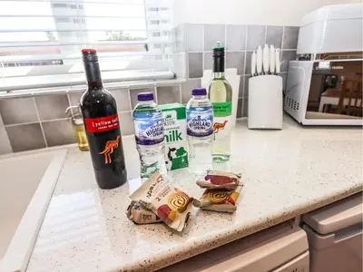 a kitchen counter with bottles of wine and food at 3 Rothbury Place in Lytham St Annes