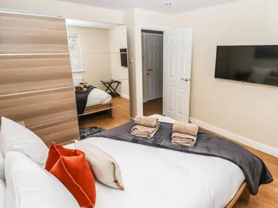 a bedroom with a bed and a tv on the wall at 3 Rothbury Place in Lytham St Annes