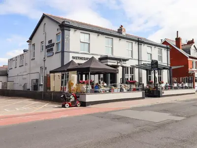 a white building on a street with a store at 3 Rothbury Place in Lytham St Annes