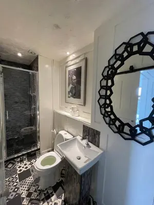 a bathroom with a toilet and a sink and a mirror at Elmora House in Blackpool