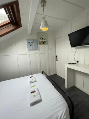 a room with a bed with a tv and a desk at Elmora House in Blackpool