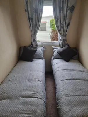 two beds in a small room with a window at elbry in Heysham