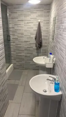 a white bathroom with a sink and a shower at Brownlows Inn Guest House formerly The King Harry Accommodation in Liverpool
