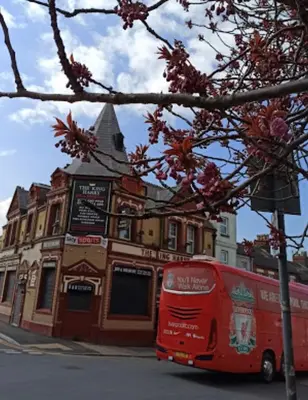 a red bus parked in front of a building at Brownlows Inn Guest House formerly The King Harry Accommodation in Liverpool