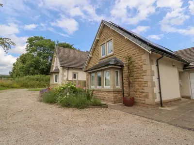 a brick house with a gravel driveway at Low Orchard House in Preston