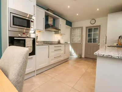 a kitchen with white cabinets and a counter at Low Orchard House in Preston