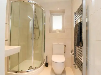 a bathroom with a shower and a toilet and a sink at Low Orchard House in Preston