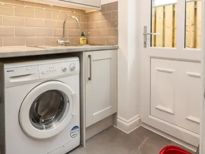 a laundry room with a washing machine and a sink at Low Orchard House in Preston