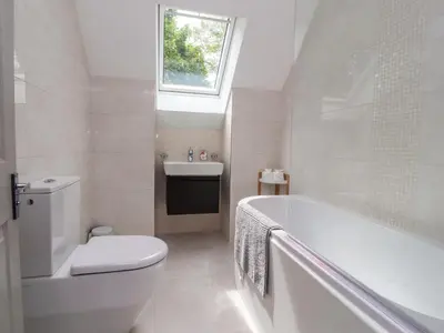 a bathroom with a tub and a toilet and a sink at Low Orchard House in Preston