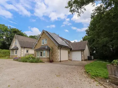 a brick house with a garage on a driveway at Low Orchard House in Preston