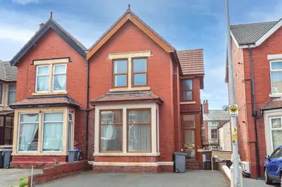 a red brick house with windows on a street at Cherry Property - Coconut Suite in Blackpool