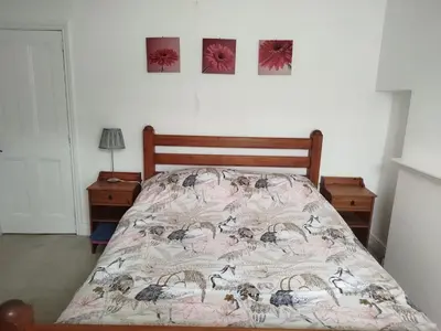 a bedroom with a bed and two pictures on the wall at Cosy end terrace in Lancaster