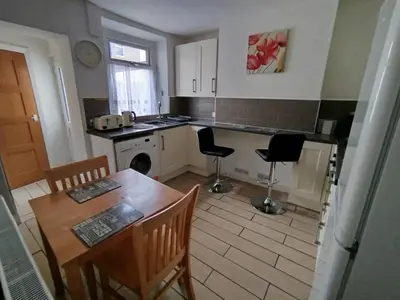 a kitchen with a table and a table and chairs at Cosy end terrace in Lancaster