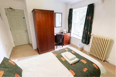 a bedroom with a bed and a desk in it at Whalley Abbey - B&B and Retreat House in Whalley