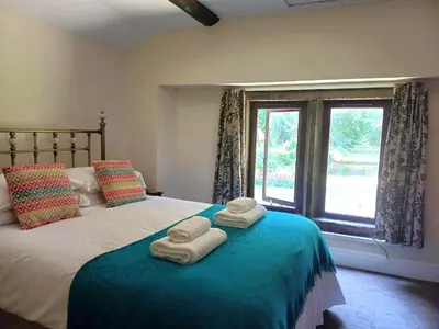a bedroom with a large bed with towels on it at Whalley Abbey - B&B and Retreat House in Whalley