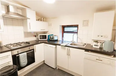 a white kitchen with a sink and a stove at Whalley Abbey - B&B and Retreat House in Whalley