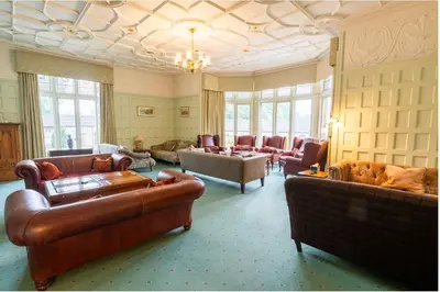 a living room with couches and chairs and a chandelier at Whalley Abbey - B&B and Retreat House in Whalley