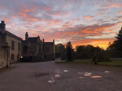 an old building with a sunset in the background at Whalley Abbey - B&B and Retreat House in Whalley