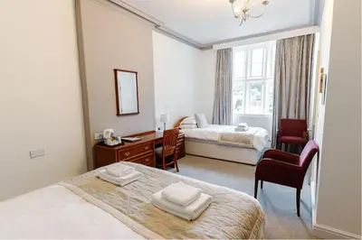 a bedroom with a bed and a desk with a chair at Whalley Abbey - B&B and Retreat House in Whalley