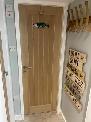 a door in a hallway with a sign on the wall at Tiny Beach House in Saint Annes on the Sea